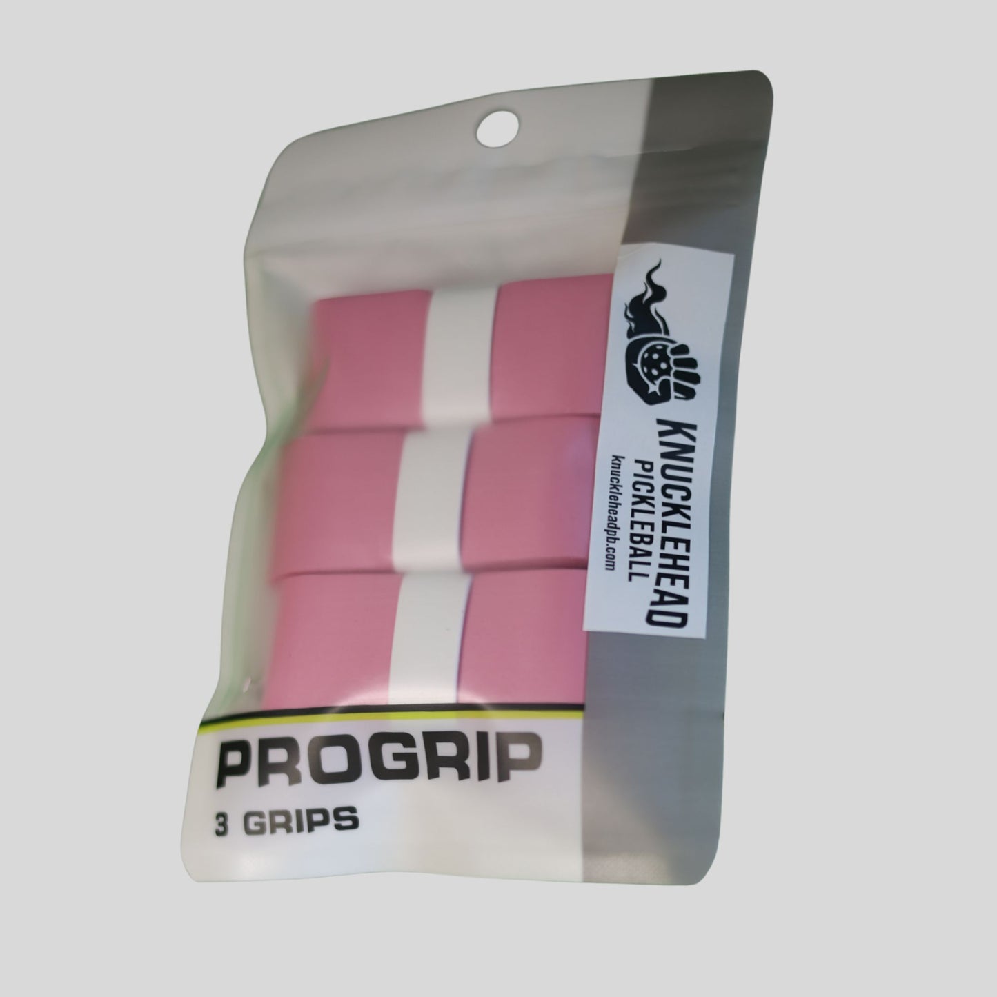 Three pink and white ProGrip pickleball grips inside a clear plastic hanging pouch with a gray side panel and a white brand label reading Knucklehead Pickleball.