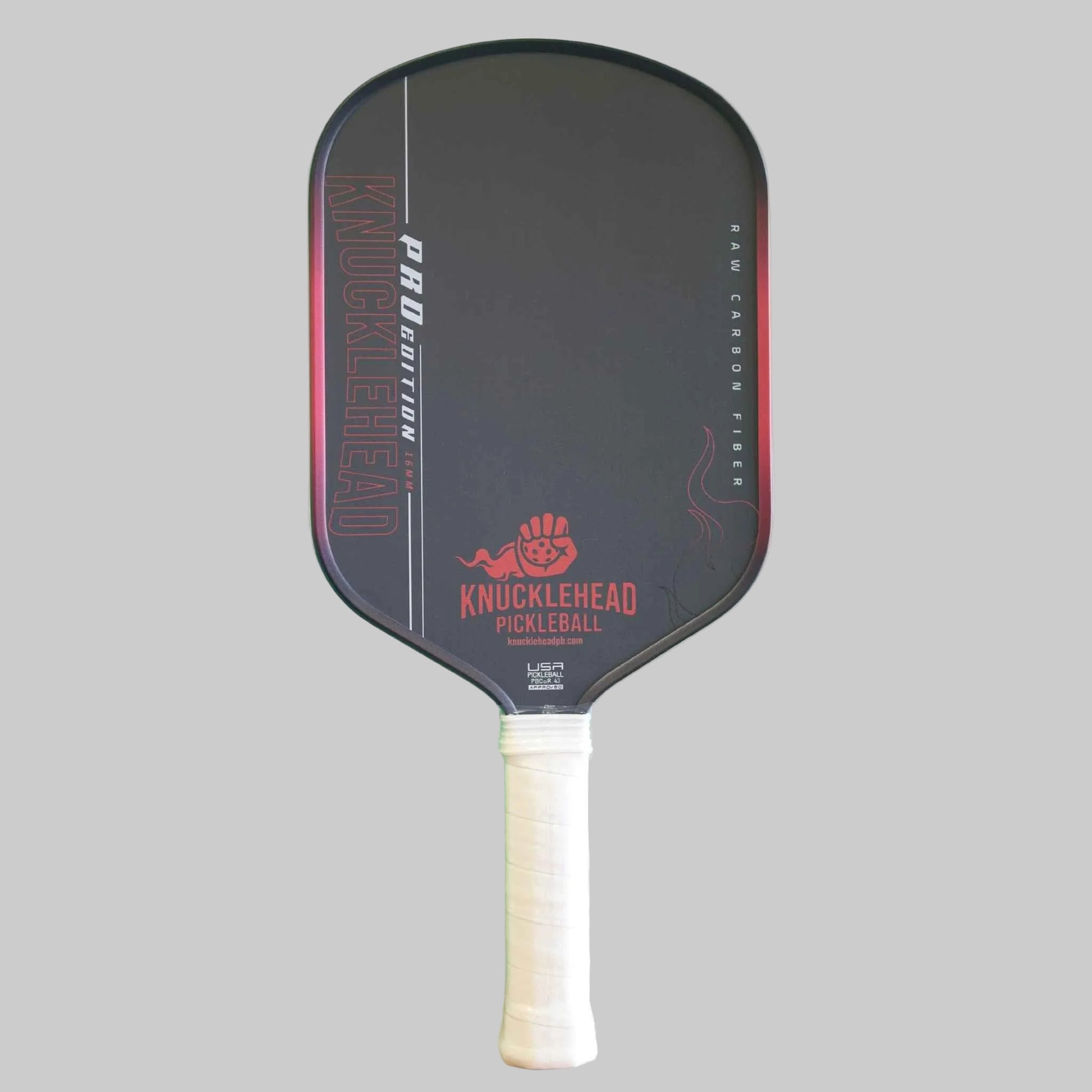 A Knucklehead pickleball paddle with a black face, red and white branding, and a white wrapped handle, shown against a solid gray background.